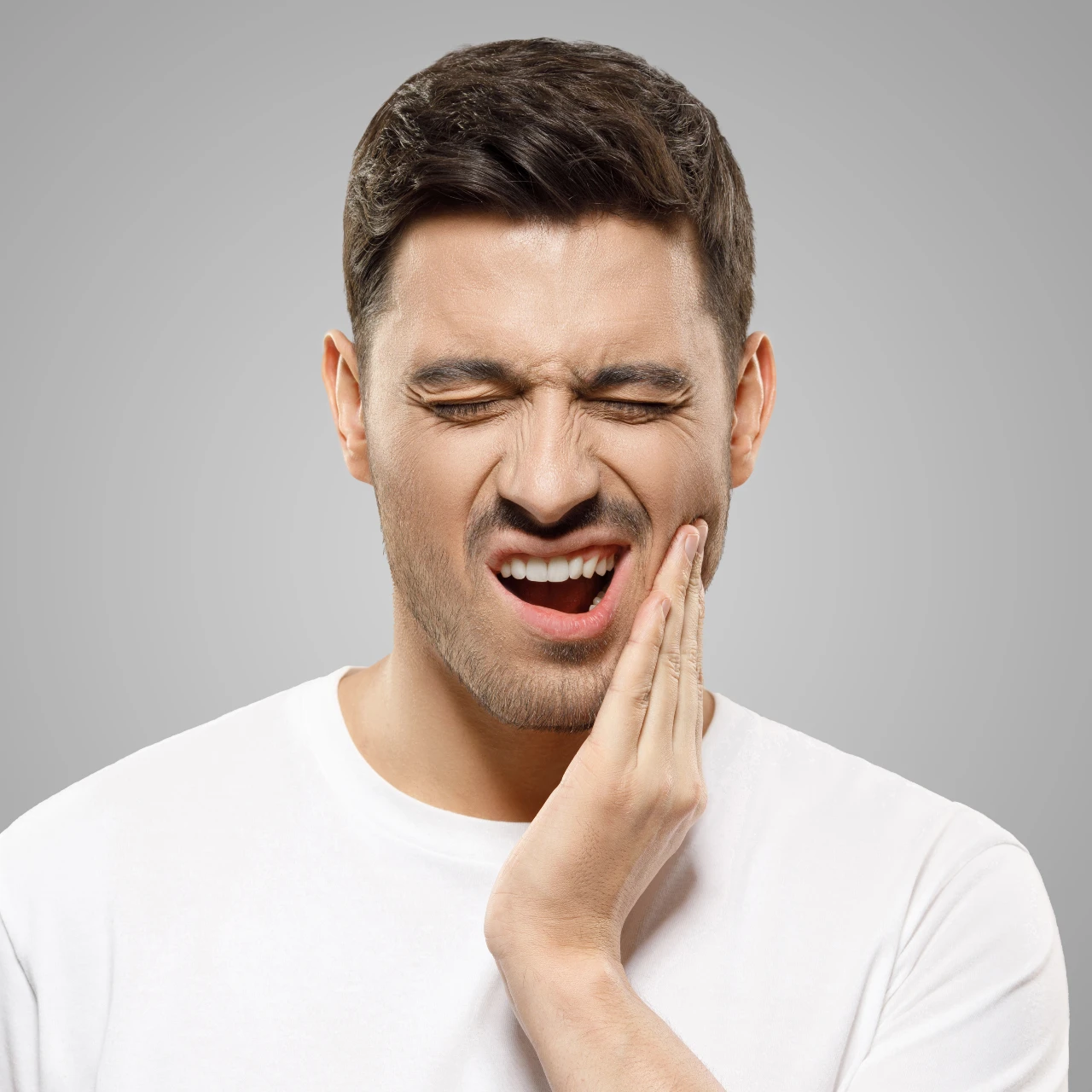 man rubbing jaw in pain and needs tmj treatment